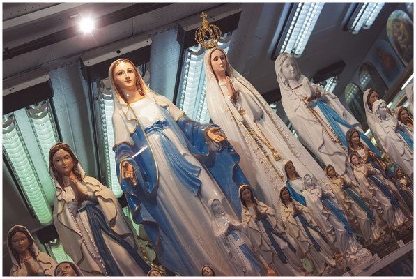Schaufenster voller Marienstatuen – Devotionalien als sichtbarer Glaube.