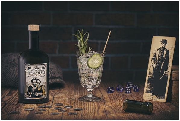 Huckleberry Gin und Gin Tonic im Glas auf Holzplatte