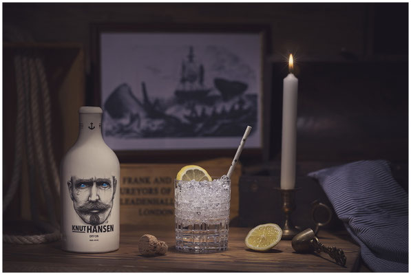 Hansen Gin Flasche und Glas und Kerze