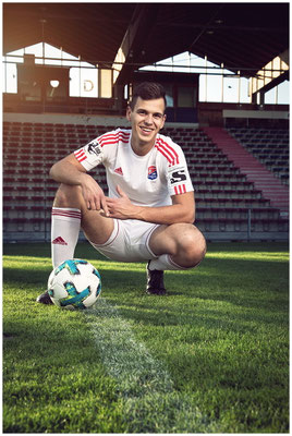 Fußballspieler-Porträt mit Ball – Symbol für Präzision, Stärke und Teamspirit.