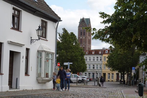 Im Hintergrund ist der Turm der St. Georgen Kirche zu sehen, auf dessen Plattform man einen Rundumblick auf Wismar hat