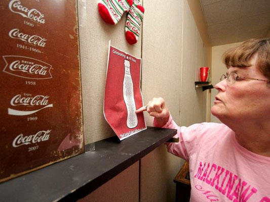 Kathy Westveld points to a listing of Coca-Cola conventions that her and her husband have attended since 2003. Rob Wetterholt Jr./Sentinel Staff