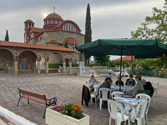 Enjoying super tasty food in Dadia with the Agios Nikolaos Church in the background.