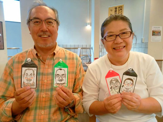 似顔絵ワークショップ　ご夫婦でお互いを描いたネームタグを持って