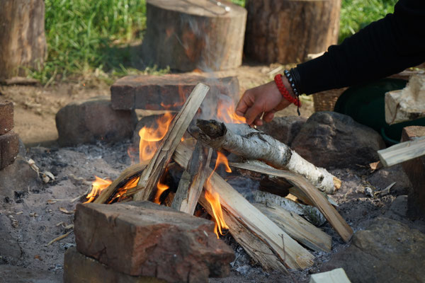 Lagerfeuer im Steinkreis am Abend im Camp