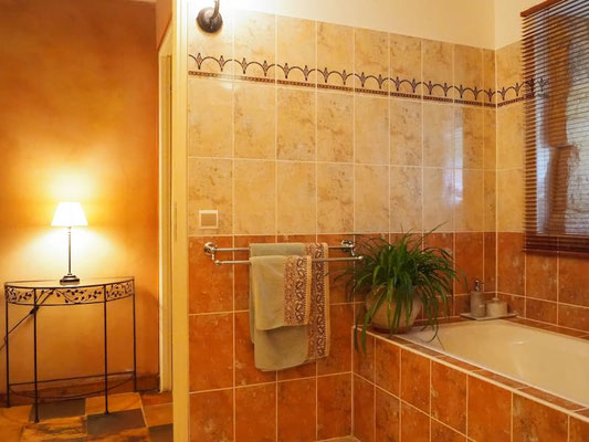 Grande salle de bain privative équipée d'une baignoire et d'une douche à l'italienne, chambre Toscane.