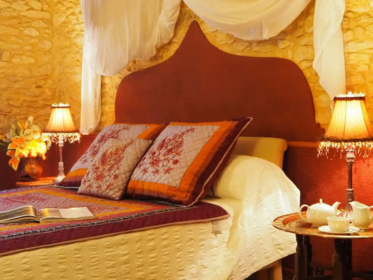 Grand lit confortable avec parure de lit style oriental dans la chambre 1001 nuits, gîte La Lysiane en Dordogne.