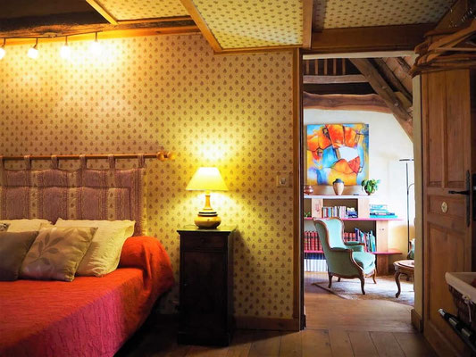 Vue depuis la chambre Rustique vers le salon commun et le coin piano de la maison d'hôtes.