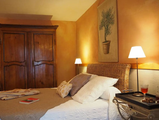 Vue sur le grand lit et l'armoire de rangement dans la chambre Toscane, gîte La Lysiane.