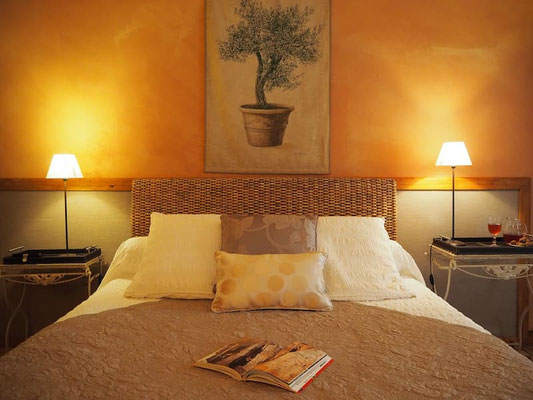 Détail de la décoration de la chambre Toscane avec un tableau d'olivier au-dessus du lit.