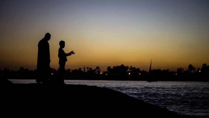 Father and sun silhouette at Nile river in Luxor