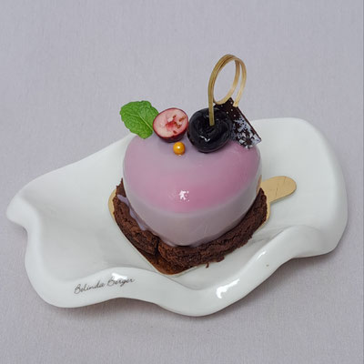 Cranberry Kirsch Sahne auf einer zartbitteren Schokoladenmousse. Stück 5,90 €.