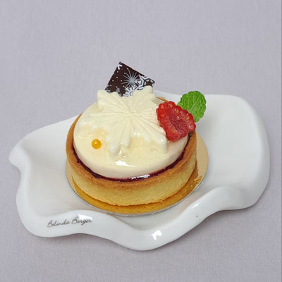Joghurtsahne mit Honig als Schneeflocke auf einem Himbeer Confit im Süßrahmbutter Tartelette. Preis pro Stück 6,30 € ( enthält Mandeln)