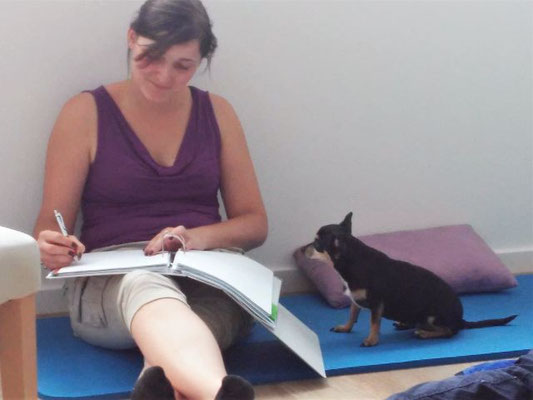 Tierkommunikation-Seminarteilnehmerin bei der Tierkommunikation mit einer kleinen, schwarzen Chihuahua-Hünden neben ihr sitzend.