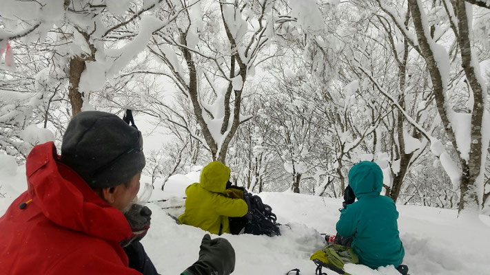 山頂の下で風をしのいで昼食休憩
