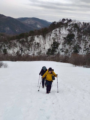 溶けて固くなった斜面をアイゼンで登る