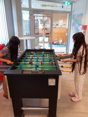 Zwei Mädchen spielen Kicker.