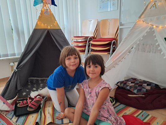 Zwei Mädchen sitzen vor den Lese-Tipis