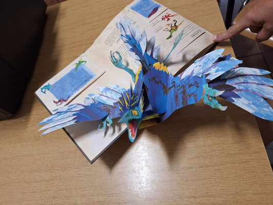 Ein Flugsaurier aus Papier klappt auf, wenn man das Buch aufschlägt