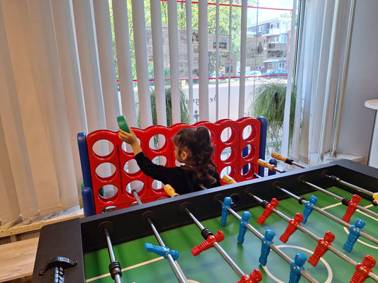 Ein Mädchen spielt mit einem großen "Vier gewinnt"-Spiel.