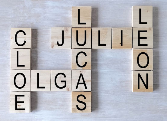 Lettres Scrabble en bois brut recyclé, avec messages personnalisés, posées sur un fond blanc