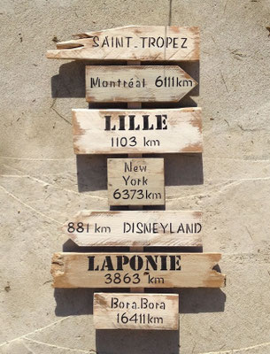 Panneau directionnel esprit bois flotté, blanc et beige avec un aspect vieilli par la mer, villes peinte en noir 
