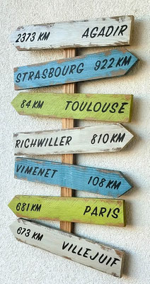 Panneau fléché déco en bois bleu et vert, texte peint en noir personnalisable, pour décoration extérieure.