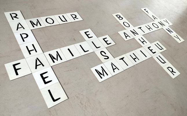 Scrabble mural petit budget en bois de balsa, personnalisé avec prénoms peints à la main et collé sur un support beige