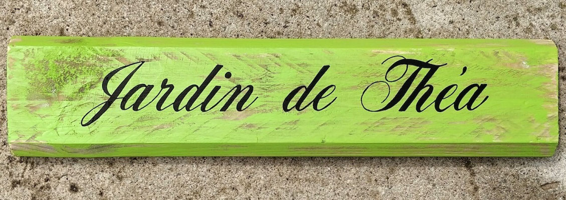 Pancarte bois personnalisée en vert pomme indiquant "Jardin de Théa" calligraphié en noir