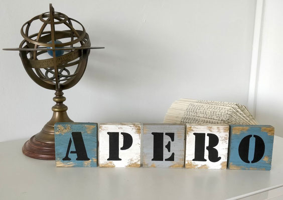 Lettres grand format pour Scrabble bois blanc, gris et bleu, posées sur un meuble blanc, texte "Apéro" peint en noir