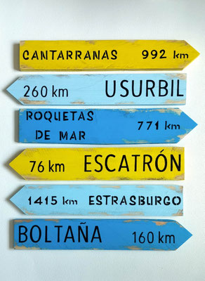 Panneau fléché tricolore en bois peinture bleue et jaune poncée, villes d'Espagne et distances peints en noir.