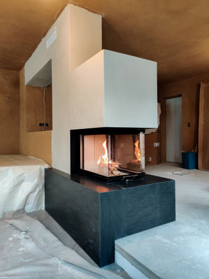 Der Kamin ist Blickfang, Raumtrennung und sorgt für Wärme in der Übergangszeit