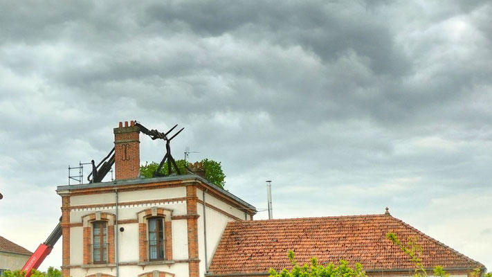 Les débris calcinés de la charpente sont retirés à l'aide d'un engin élévateur.