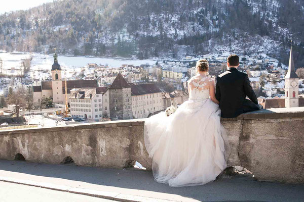 Brautpaar auf der Mauer, hoch über Chur, Weitsicht auf die Stadt, Hochzeitsfotografin negri, Liebesgschicht-fotografie