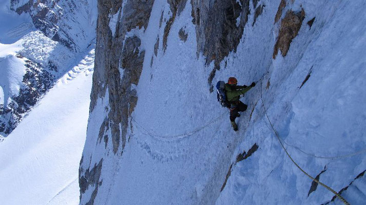 Tiefblick nach der 150 m langen Traverse in die NW-Flanke; Ralf im Aufstieg am Fixseil © Gerlinde Kaltenbrunner