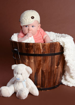 Baby im Holzeimer im Fotostudio