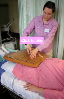 Pia Tecklenberg-Jansson, musical therapist and researcher playing on a woman in the University Clinic Helsinki
