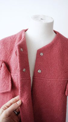 The coat closes with two big, metal press buttons that are hidden under decorative self buttons for a clean look.