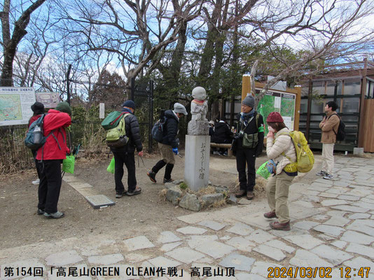 ゴミ拾い：高尾山頂のシンボル「おそうじ小僧」の周りでごみを探す