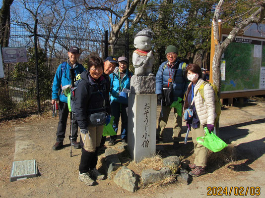 ゴミ拾い：高尾山頂のシンボル「おそうじ小僧」を囲んで