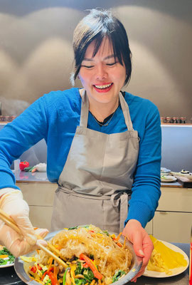 Teilnehmerin bereitet Japchae im koreanischen Kochkurs von Bilou Kitchen in München zu.