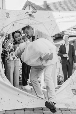 Bräutigam trägt seine Braut durch ein Herz Hochzeitsfotograf Herford