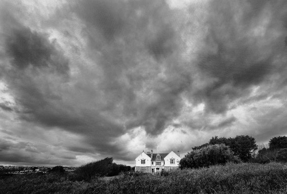 Sturmwolken über einem weißen Haus, Wales 2014
