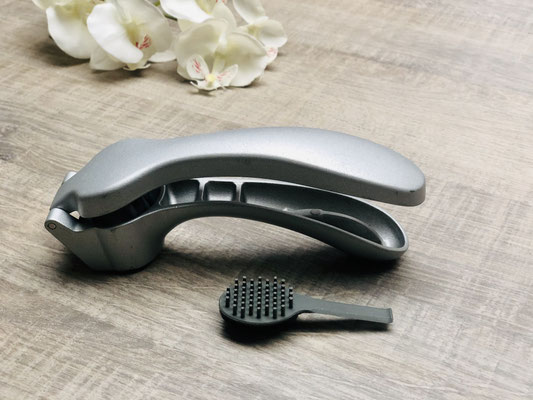 Hier siehst du die Knoblauch/-Ingwer Presse von Pampered Chef. Das Bürstchen ist das Reinigungsutensil der Knoblauchpresse von Pampered Chef.