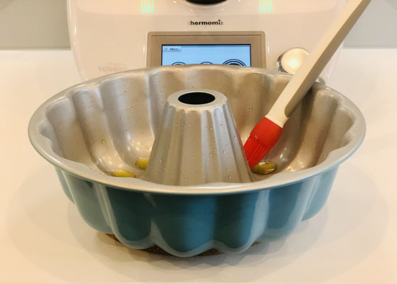 Die Gugelhupf/Kranzform von Pampered Chef mit dem Silikonpinsel gut einfetten und den Teig hineingeben und mit dem Mix´N Scraper glatt streichen