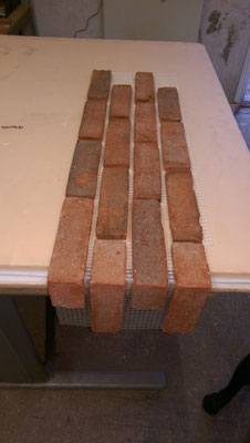 BrickMesh standard sheet coupling with BrickMesh corner sheet laid on a table. Consisting red brick slips adhered to a fibreglass mesh backing.