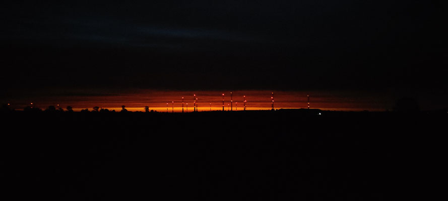 Was braut sich da wohl zusammen? Wunderschöner Sonnenaufgang, akzentuiert mit Windrädern. 