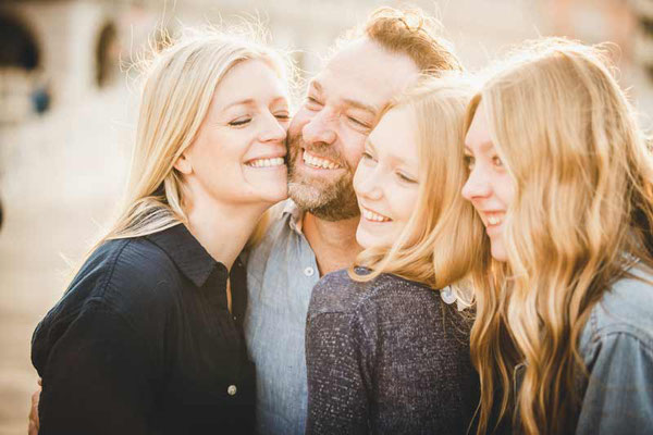 A family in Venice, captured in a joyful embrace, with the iconic canals reflecting their happiness during the photoshoot.