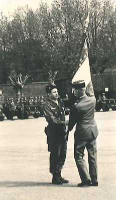 Gros plan sur la remise du drapeau au chef de corps.