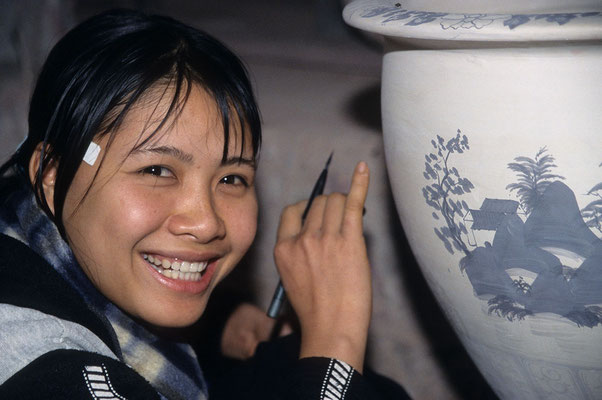Mädchen beim Bemalen einer Tonvase in einer Töpferei auf der Fahrt in die Halongbucht. Auf dem Boden der Vase stand: "made in Vietnam for Ikea / Sweden"